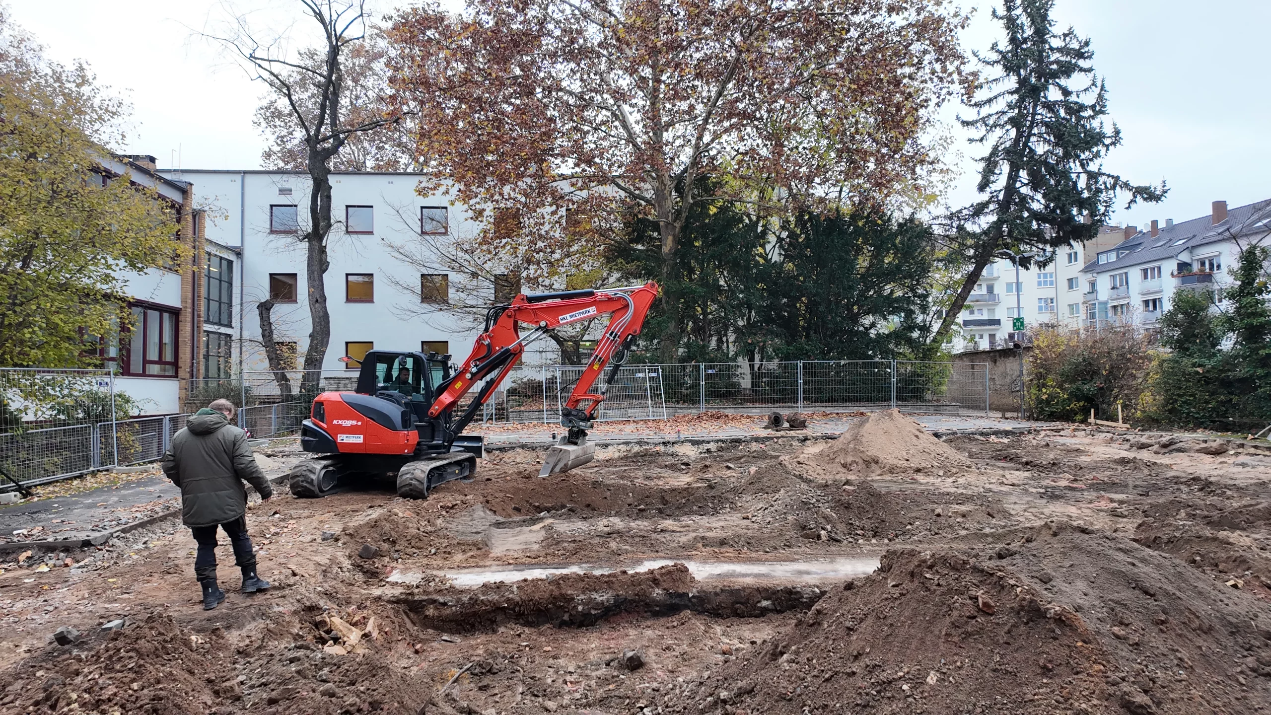 Aushubarbeiten Uhlandschule Frankfurt – Suppro GmbH freigelegte Schulhoffläche mit Bagger und Bauleitung