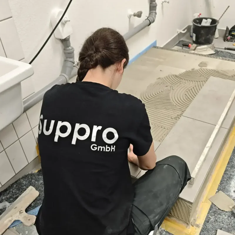 Fliesenleger der Suppro GmbH verlegt Bodenfliesen bei einer Badsanierung im Rhein-Main-Gebiet