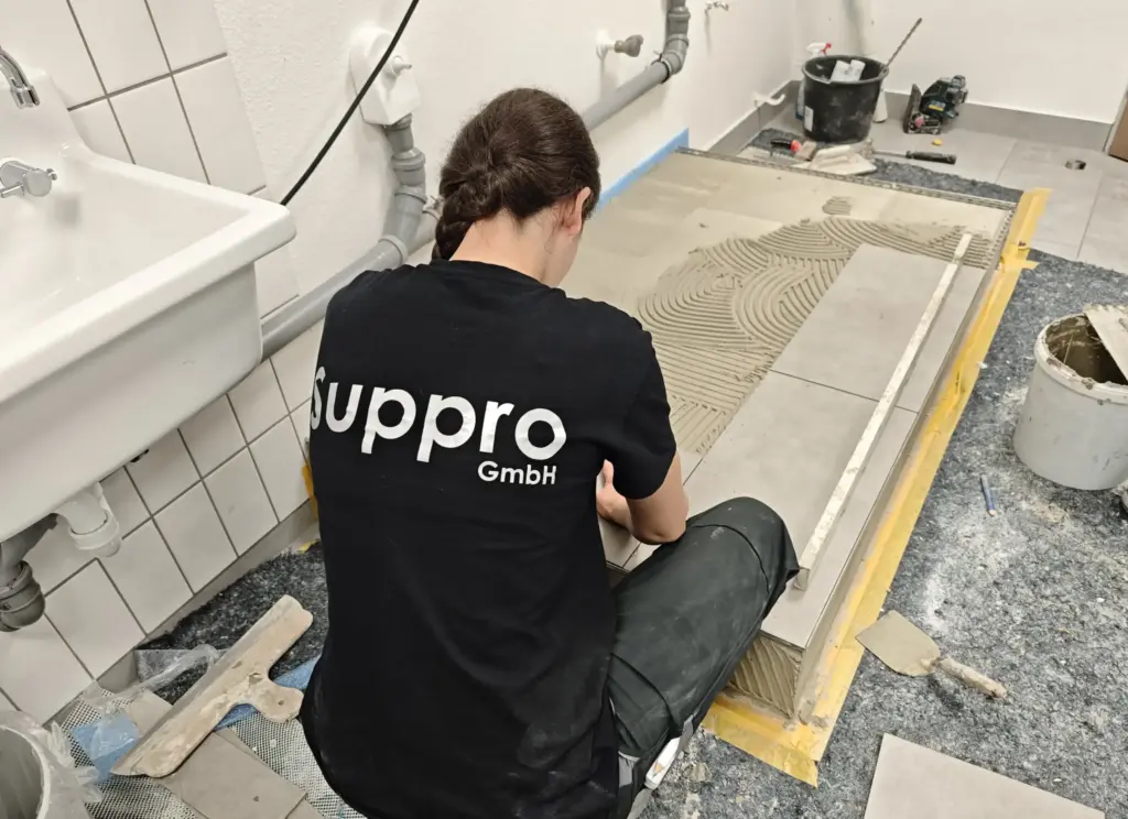 Fliesenleger bei der Arbeit im Bad, Suppro GmbH, Jobs als Baufacharbeiter/Fliesenleger im Rhein-Main-Gebiet