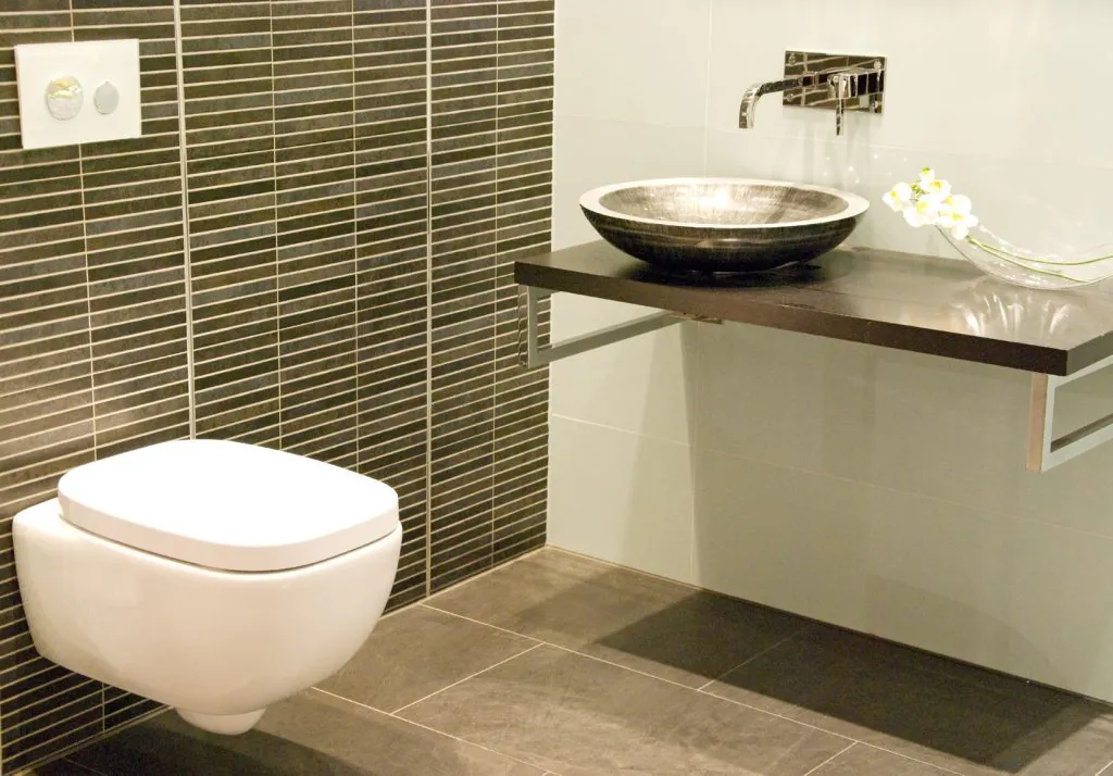 Modernes Gäste-WC nach Badsanierung in Friedrichsdorf mit Hänge-WC, Waschtisch und stilvollen Fliese
