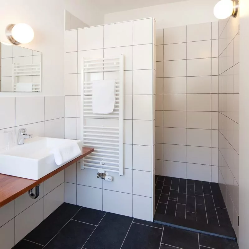 Modernes Badezimmer nach Badsanierung in einer Privatwohnung in Frankfurt – Fliesenarbeiten, Waschbecken und Dusche